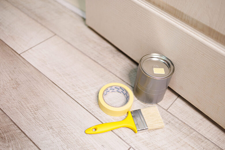 Une Panne De Peine Et Un Brosse à Peinture Sont Sur Le Plancher Répare